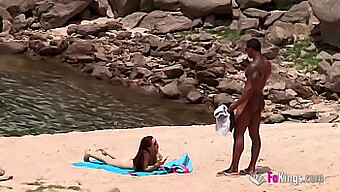 A well-endowed African man encounters a nude beachgoer in this amateur outdoor video